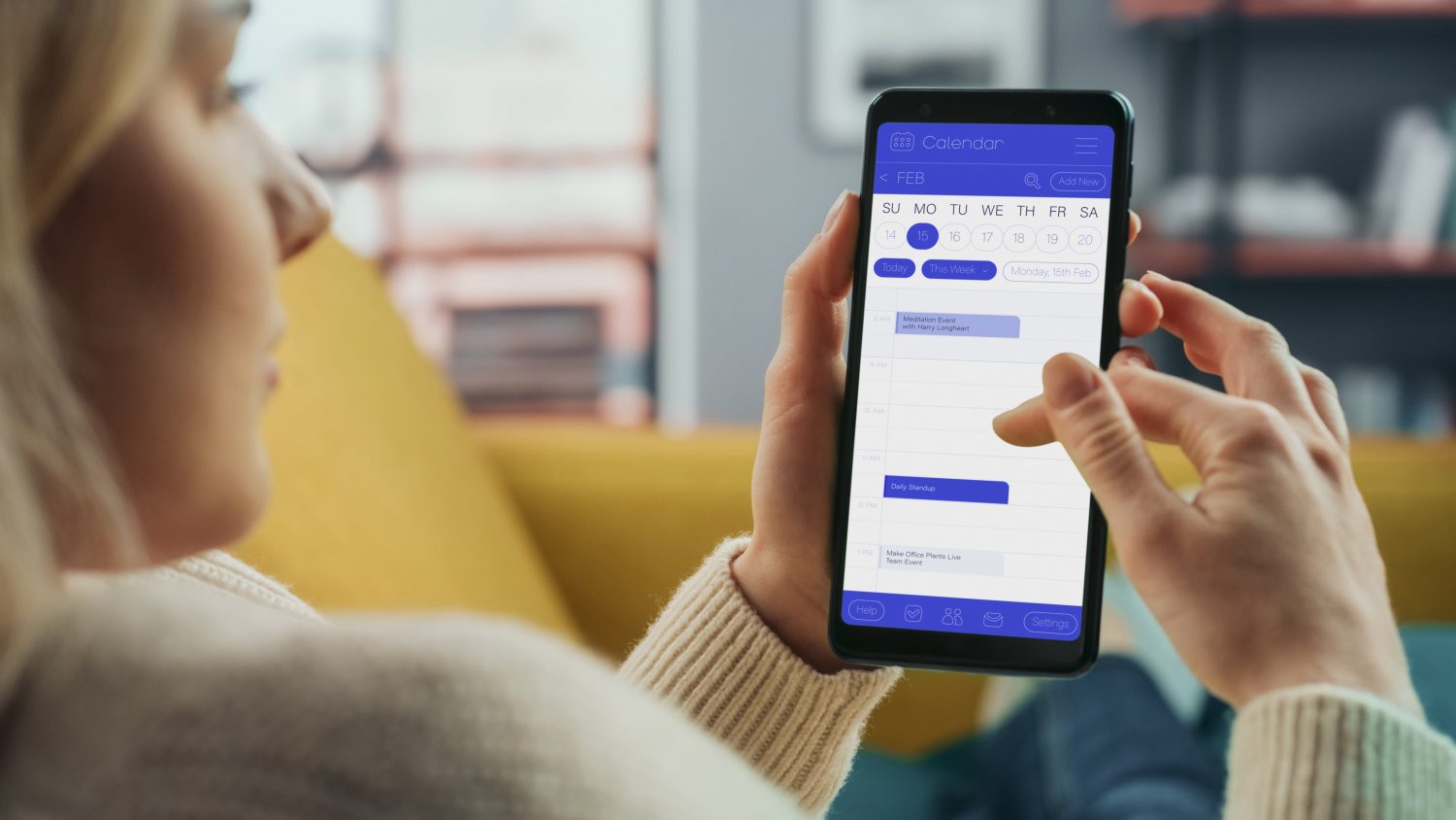 Beautiful Authentic Female Using a Smartphone with Calendar Application at Home Living Room while Lying on a Couch Sofa. She's Making Plans and Checking Event Schedule for a Day.